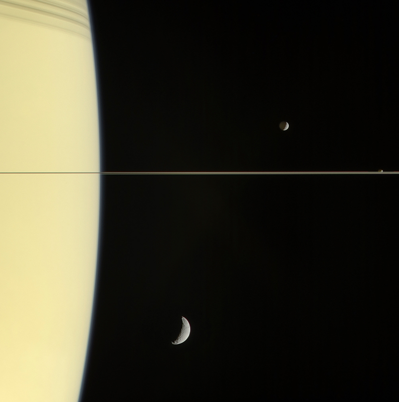 Three of Saturn’s moon are visible: Mimas (above the ring line), Janus (just touching ring line), and Tethys (below).